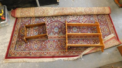 Lot 1556 - A large machine woven rug, on blue ground,...