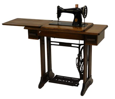 Lot 836 - A Singer treadle sewing machine in walnut...