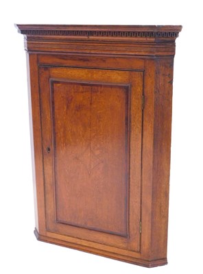 Lot 855 - A George III oak hanging corner cupboard, with...