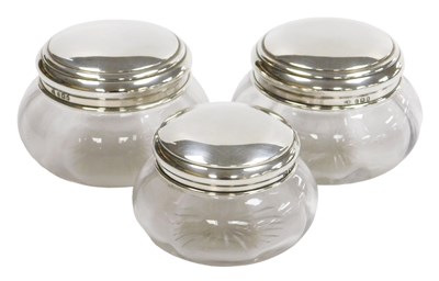Lot 115 - Three George V cut glass dressing table jars,...