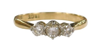 Lot 207 - A diamond three stone ring, claw set in yellow...