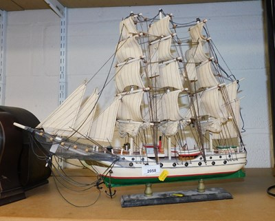 Lot 2058 - A painted model of a three masted ship, on an...