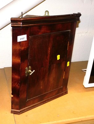 Lot 2107 - A mahogany wall hanging corner cabinet, the...
