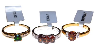 Lot 560 - A cinnamon zircon and white topaz three stone...