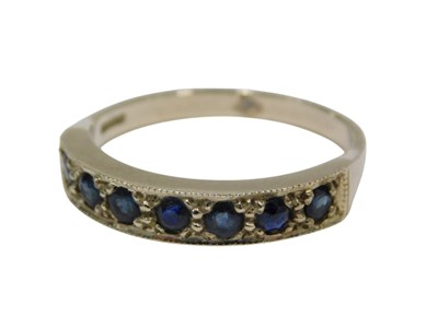Lot 165 - A 9ct white gold sapphire half hoop dress ring,...