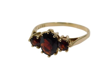 Lot 129 - A 9ct gold three stone garnet dress ring, of...