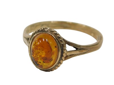Lot 134 - A 9ct gold amber dress ring, with cabochon cut...
