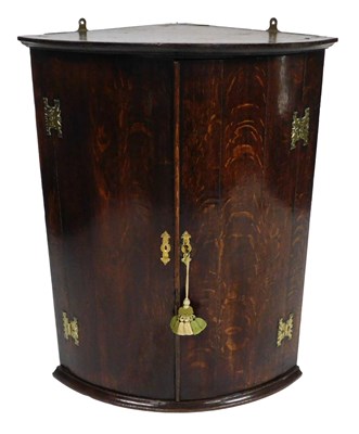 Lot 702 - A George III oak hanging bow front corner...