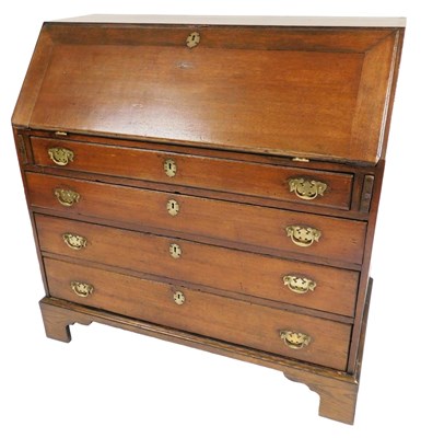 Lot 677 - A George III oak bureau, the fall flap opening...