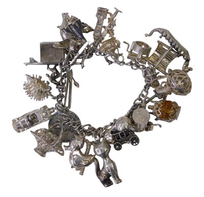 Lot 398 - A silver charm bracelet, the silver hammered...