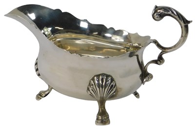 Lot 418 - A George V silver sauce boat, with part fluted...
