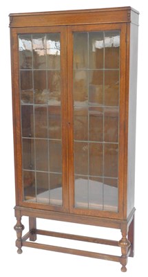 Lot 576 - An early 20thC oak display cabinet, with two...