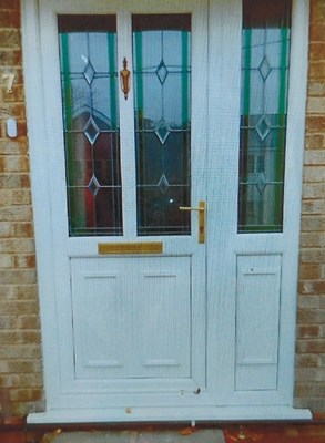 Lot 1122 - An aluminium UPVC front door, with leaded...