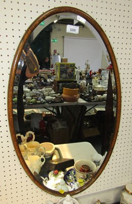 Lot 2228 - A wooden framed oval bevelled wall mirror.