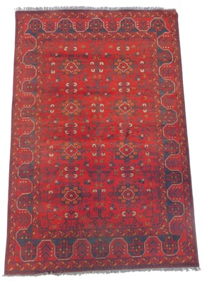 Lot 689 - An Afghan red ground rug, decorated with two...
