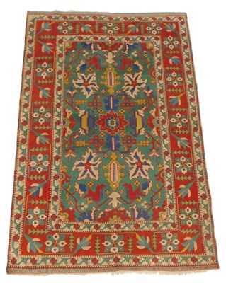 Lot 699 - A Turkish green and red ground rug, decorated...