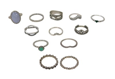 Lot 334 - Twelve silver dress rings, of varying designs,...