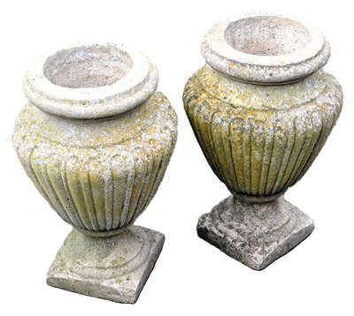 Lot 454 - A pair of composition stone urns, with fluted...