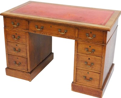 Lot 535 - An Edwardian oak twin pedestal desk, with red...