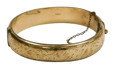 Lot 630 - A 9ct gold plated bangle, with engraved...