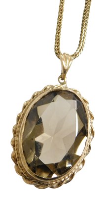 Lot 222 - A 9ct gold and smoky quartz pendant, the oval...