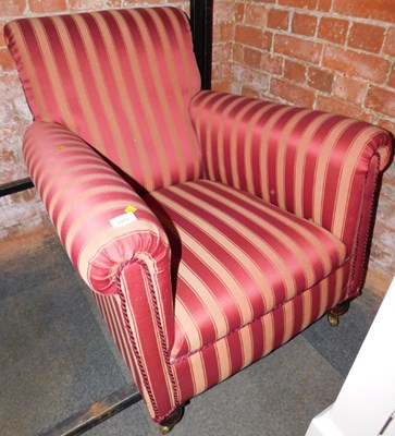 Lot 1071 - An armchair upholstered in red striped fabric.