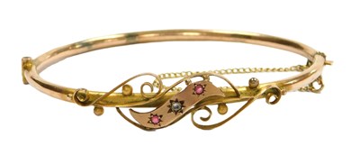 Lot 219 - A 9ct two colour gold diamond and ruby bangle,...