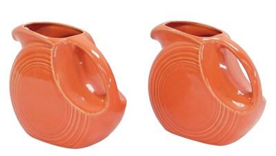 Lot 407 - Two Fiesta ware coral coloured pottery jugs,...