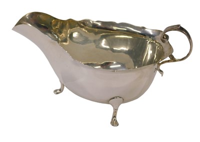 Lot 79 - An Edward VII silver sauceboat, on tripod claw...