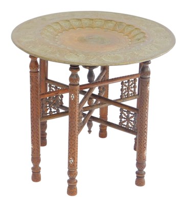 Lot 511 - An Indian brass tray top table, with engraved...