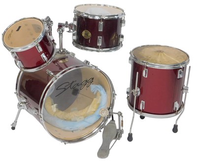 Lot 530 - A Stagg four piece drum kit, in red and black...