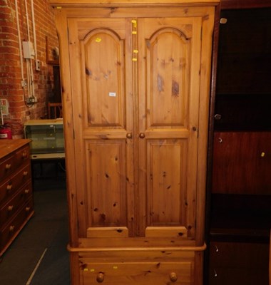 Lot 1106 - A pine double wardrobe, with a single drawer...