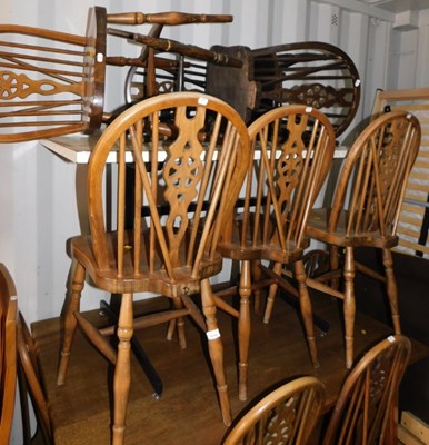 Lot 1079 - Ten wheel back dining chairs, each with a...