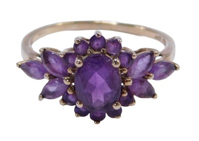 Lot 141 - An amethyst cluster dress ring, the central...