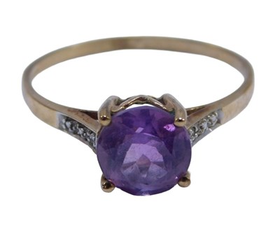 Lot 142 - An amethyst dress ring, the central round...