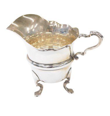 Lot 153 - A George V silver milk jug, with fluted border...
