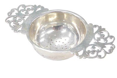 Lot 177 - A George V silver tea strainer, with scroll...