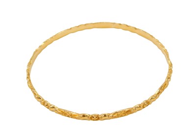 Lot 455 - An Eastern hammered gold plated bangle, with...