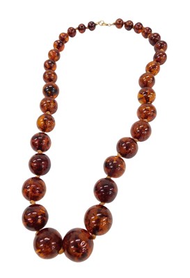 Lot 457 - A graduated amber necklace, with spherical...