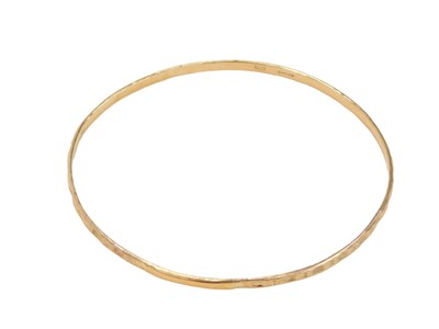 Lot 466 - A 9ct gold bangle, of half hammered...