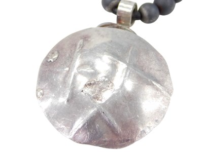 Lot 472 - A hematite pendant and chain, the hammered...