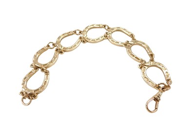Lot 15 - A 9ct gold horseshoe bracelet, formed as seven...