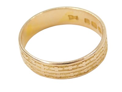 Lot 251 - An 18ct gold wedding band, of patterned design,...