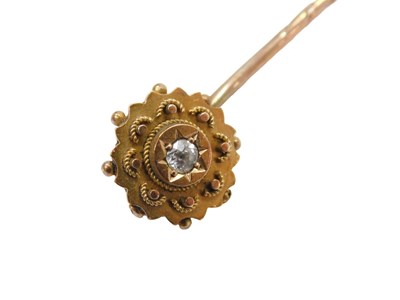 Lot 291 - A diamond set stick pin, the layered floral...