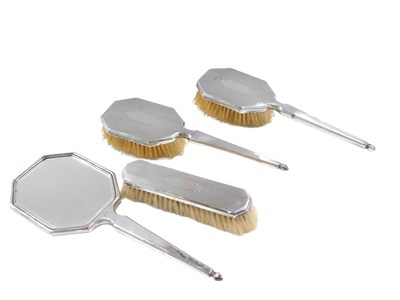 Lot 573 - A George V silver backed four piece dressing...