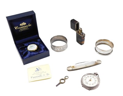 Lot 562 - A group of trinkets, comprising a silver fob...