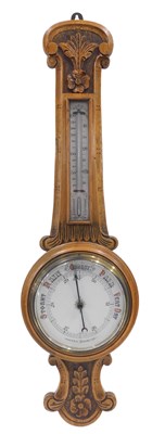 Lot 872 - A 20thC oak aneroid barometer, with carved...