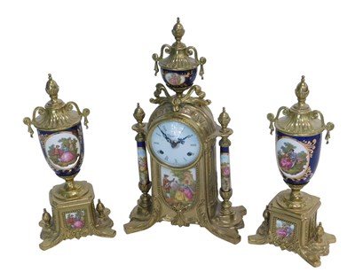 Lot 1089 - A Continental brass effect and porcelain clock...