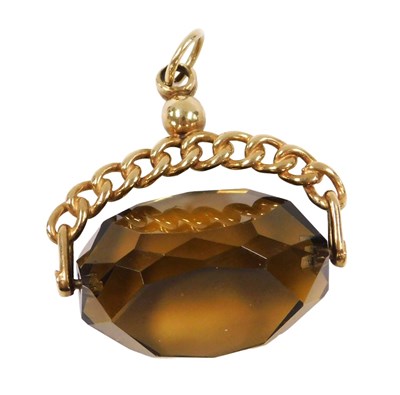 Lot 214 - A faceted smoky quartz swivel fob, in a yellow...