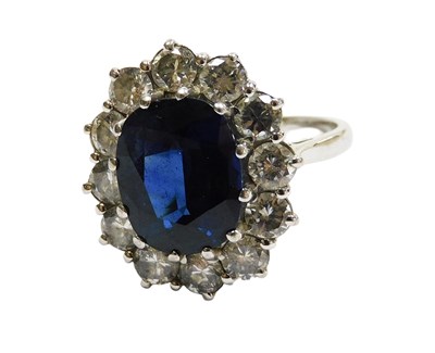 Lot 220 - An 18ct gold sapphire and diamond oval cluster...